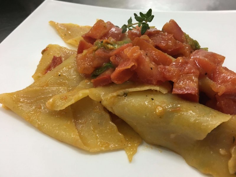 Stracci di pasta tirata a mano con fiori di zucca e pomodoro fresco